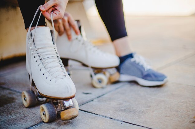 Mulher sentada segurando laços de patins