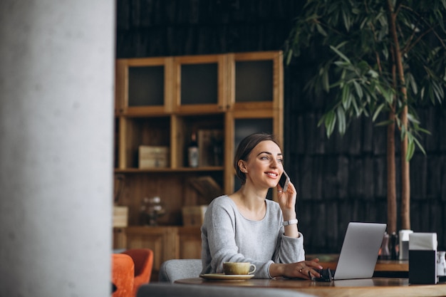 Mulher, sentando, em, um, café, café bebendo, e, trabalhar, um computador