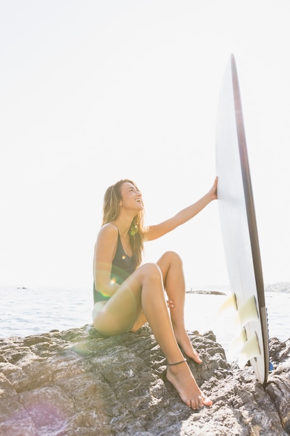 Foto grátis mulher, sentando, ligado, rochoso, costa mar, com, surfboard