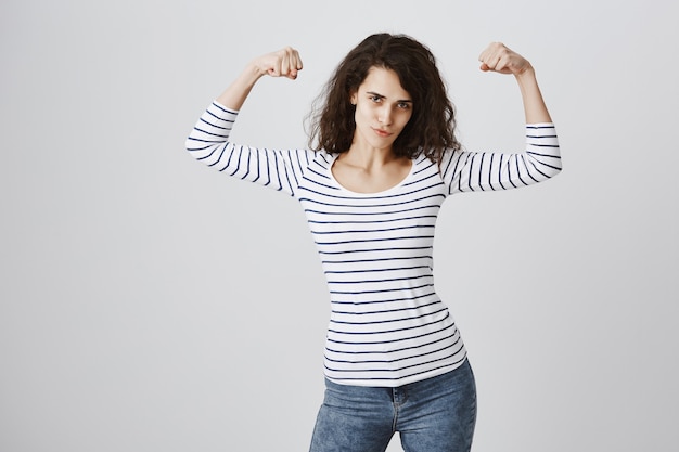 Mulher sentindo-se fortalecida flexionando bíceps após o treino