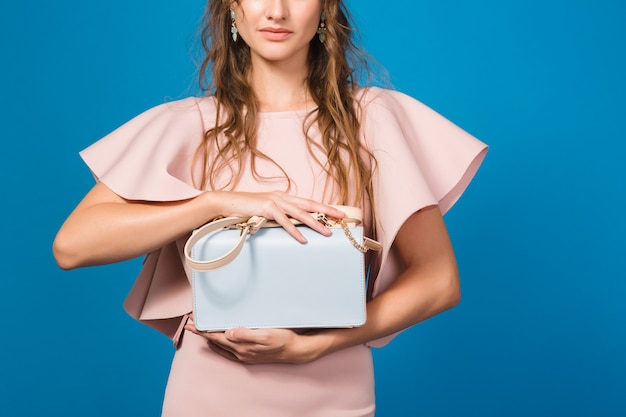 Mulher sexy elegante jovem e sedutora em um vestido de luxo rosa, tendência da moda de verão, estilo chique, segurando uma bolsa da moda