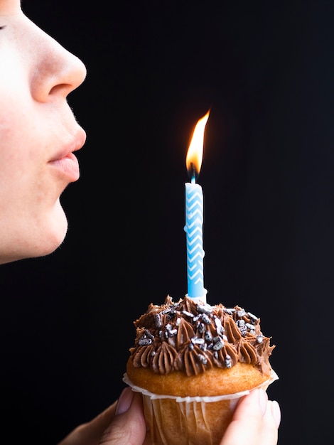 Foto grátis mulher soprando uma vela de aniversário