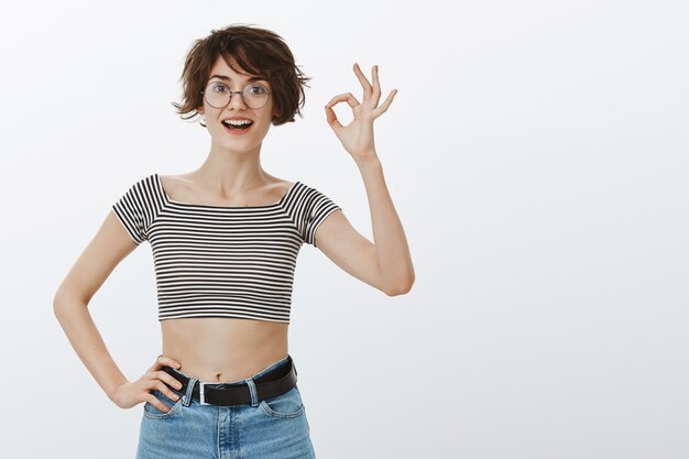 Mulher sorridente alegre mostrando tudo bem em aprovação, curtir e concordar, recomendar, elogiar bom trabalho ou escolha perfeita