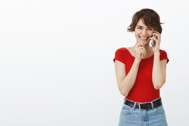 Mulher sorridente alegre rindo, falando no celular feliz