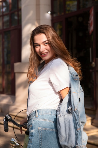 Mulher sorridente andando de bicicleta ao ar livre na cidade