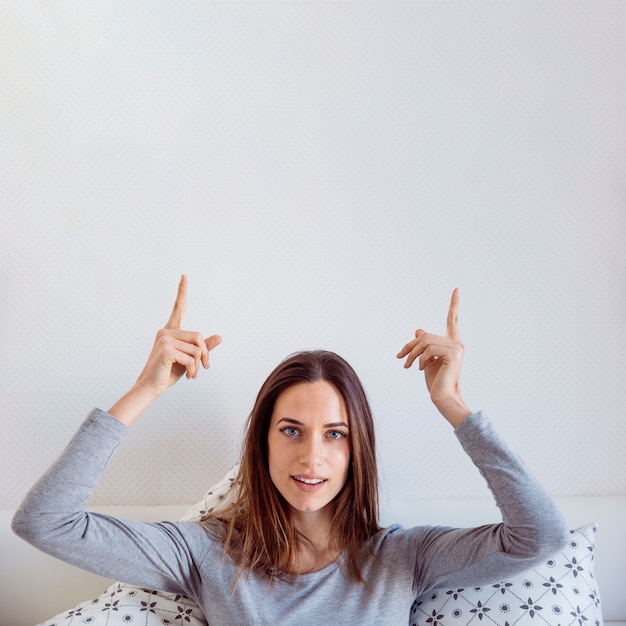 Foto grátis mulher sorridente apontando para cima