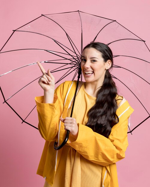 Mulher sorridente apontando para o guarda-chuva