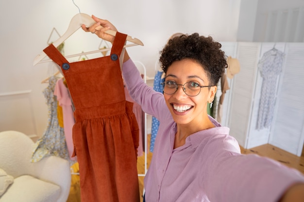 Foto grátis mulher sorridente apresentando roupas de alto ângulo