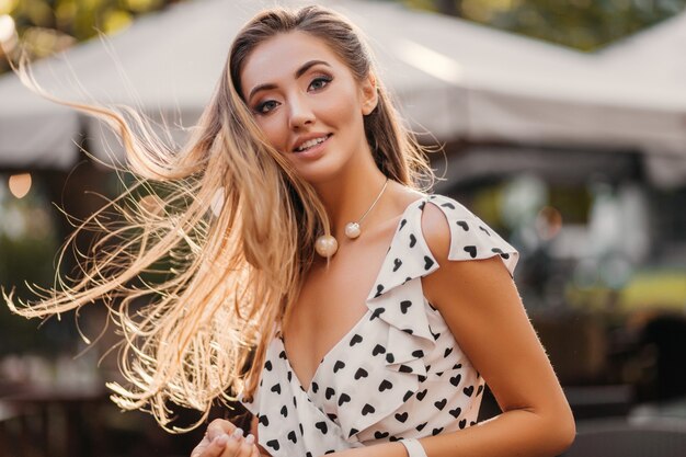 Mulher sorridente atraente com cabelo comprido se divertindo feliz em um dia ensolarado de verão