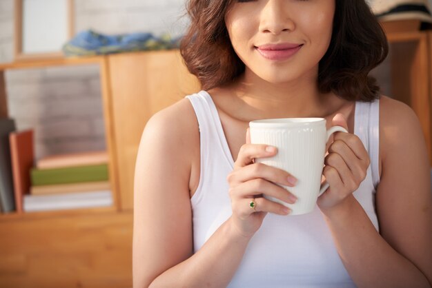 Mulher sorridente, bebendo café