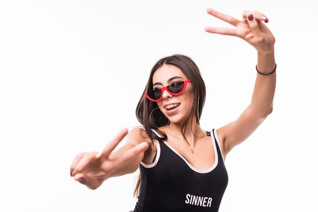 Mulher sorridente com aparelho mostra vitória cantar nas duas mãos