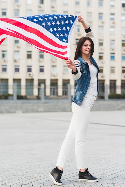 Mulher sorridente, com, bandeira americana, em, cidade