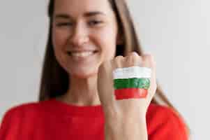 Foto grátis mulher sorridente com bandeira búlgara pintada na mão