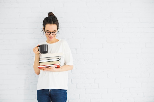 Mulher sorridente, com, copo, e, livros