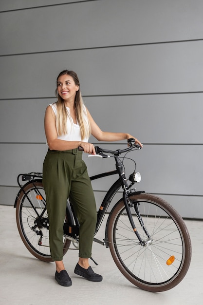 Mulher sorridente com foto completa com bicicleta