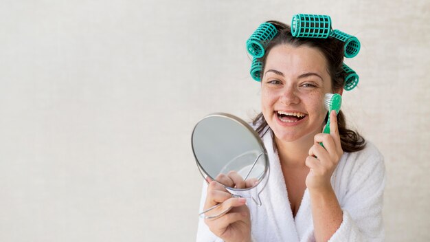Mulher sorridente com foto média escovando rosto