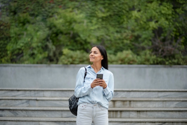 Mulher sorridente com foto média segurando o telefone