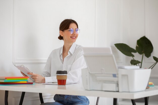 Mulher sorridente com foto média sentada à mesa