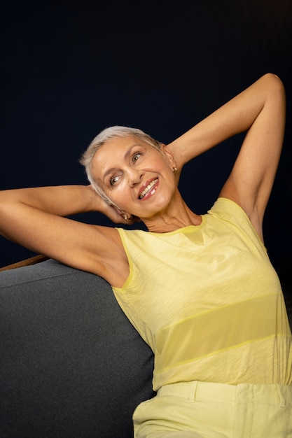 Foto grátis mulher sorridente com foto média sentada na cadeira