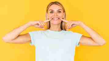 Foto grátis mulher sorridente com fundo amarelo