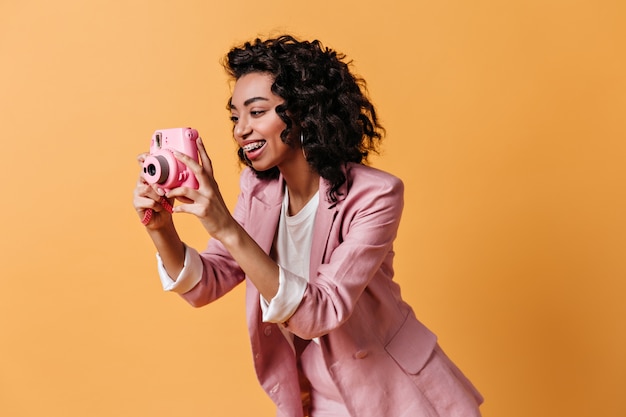 Foto grátis mulher sorridente com jaqueta rosa tirando fotos