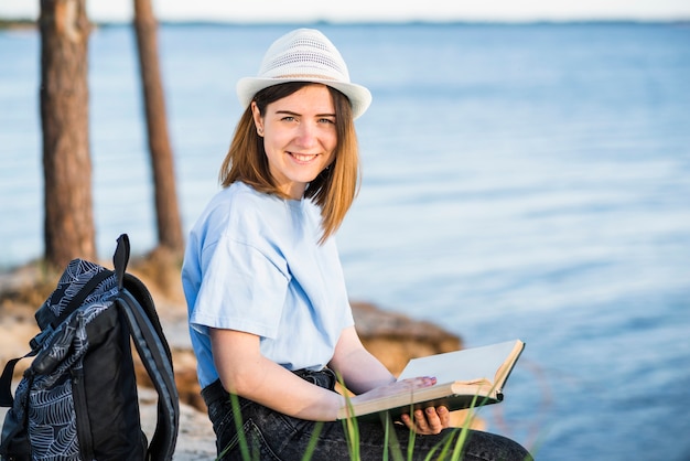 Foto grátis mulher sorridente, com, livro, olhando câmera