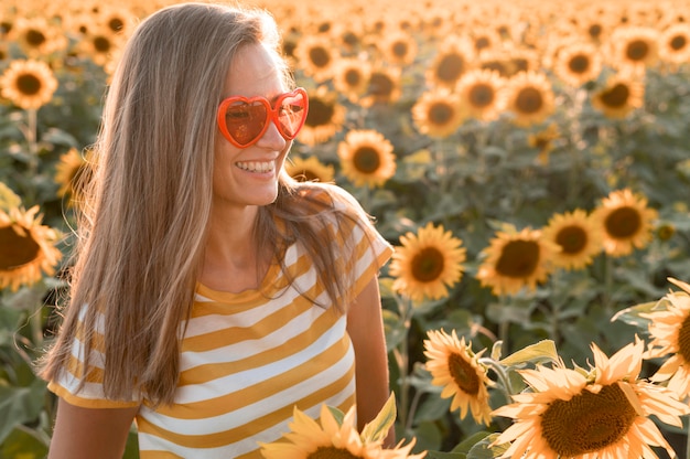 Mulher sorridente com óculos de sol em formato de coração