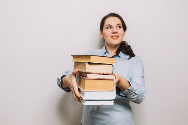 Mulher sorridente, com, pilha livros