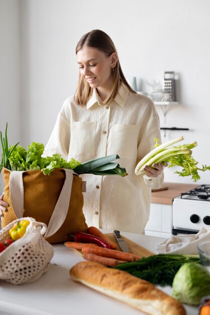 Mulher sorridente com plano médio de legumes