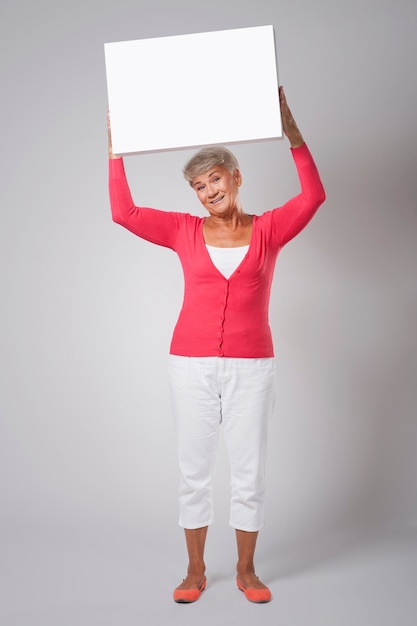 Mulher sorridente com quadro branco vazio