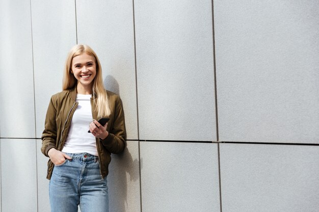 Mulher sorridente com smartphone olhando