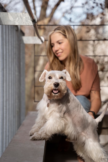 Mulher sorridente com tiro médio e cachorro Foto gratuita