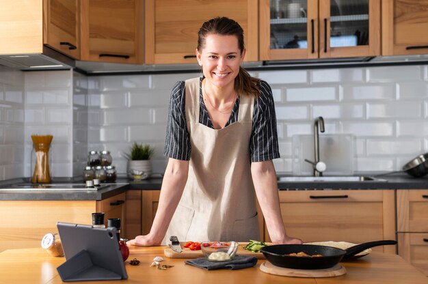 Mulher sorridente com tiro médio na cozinha