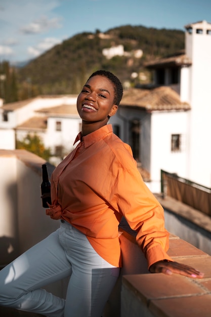 Mulher sorridente com tiro médio segurando bebida