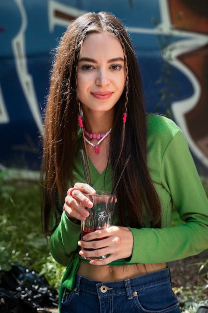 Mulher sorridente com tiro médio segurando bebida