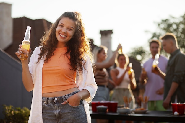 Mulher sorridente com tiro médio segurando bebida