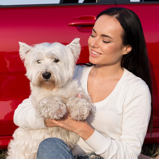 Mulher sorridente com tiro médio segurando cachorro