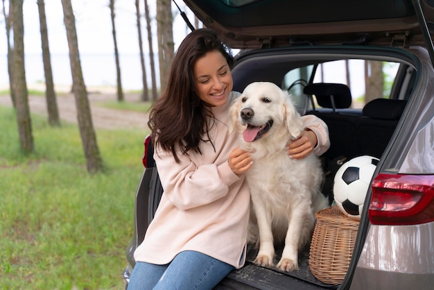 Mulher sorridente com tiro médio segurando cachorro