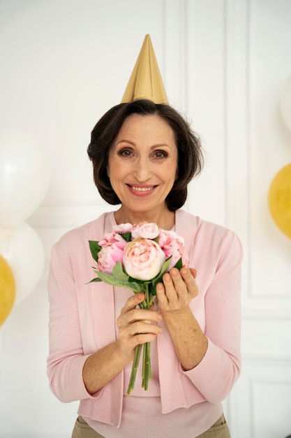 Mulher sorridente com tiro médio segurando flores