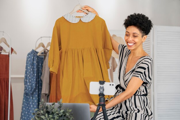 Foto grátis mulher sorridente com vista lateral de roupas