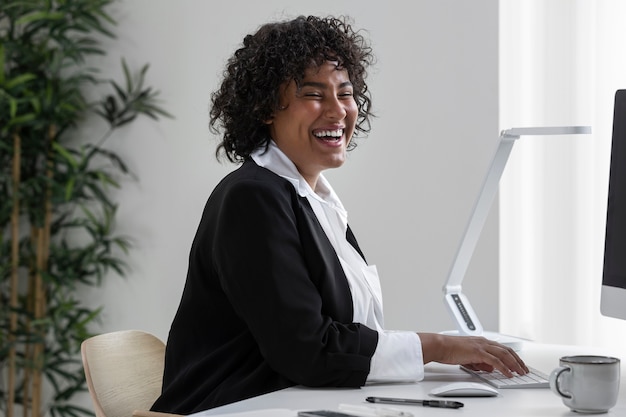 Foto grátis mulher sorridente com vista lateral trabalhando