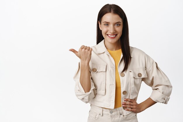 Mulher sorridente confiante apontando para a esquerda no banner de desconto de venda, mostrando o logotipo no espaço vazio em branco, recomendando clicar no link, siga esse caminho