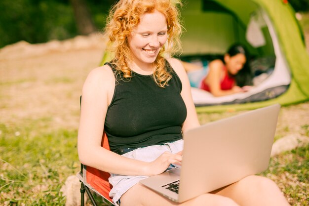 Mulher sorridente, conversando, ligado, laptop, ao ar livre