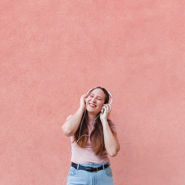 Mulher sorridente curtindo música em fones de ouvido