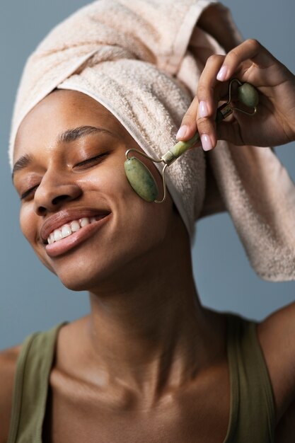 Mulher sorridente de alto ângulo usando gua sha