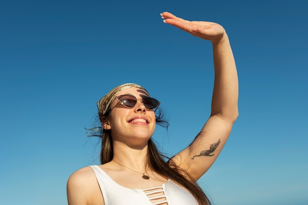 Foto grátis mulher sorridente de baixo ângulo posando na praia