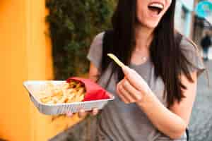 Foto grátis mulher sorridente de close-up com batatas fritas