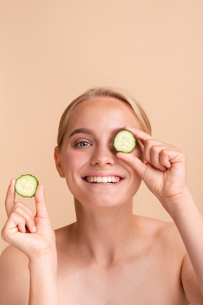 Mulher sorridente de close-up com fatias de pepino