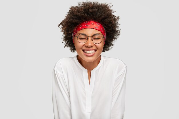 Mulher sorridente de pele escura com expressão de satisfação satisfeita, se sente feliz por estar de bom humor