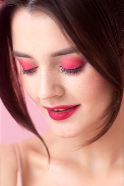 Mulher sorridente de perto com maquiagem rosa